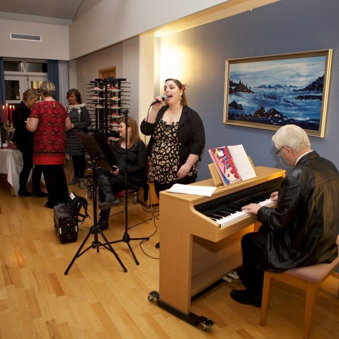 Linda Guðmundsdóttir með hljóðneman í hönd, Reynir Schiöth við píanóið. Ljósmynd: Bjarni Eiríksson.