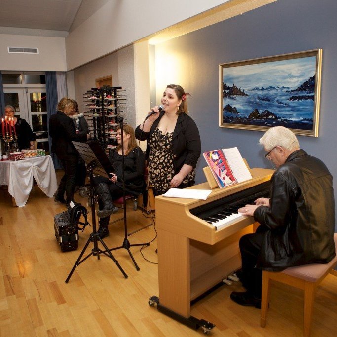 Linda Guðmundsdóttir með hljóðneman í hönd, Reynir Schiöth við píanóið. Ljósmynd: Bjarni Eiríksson.